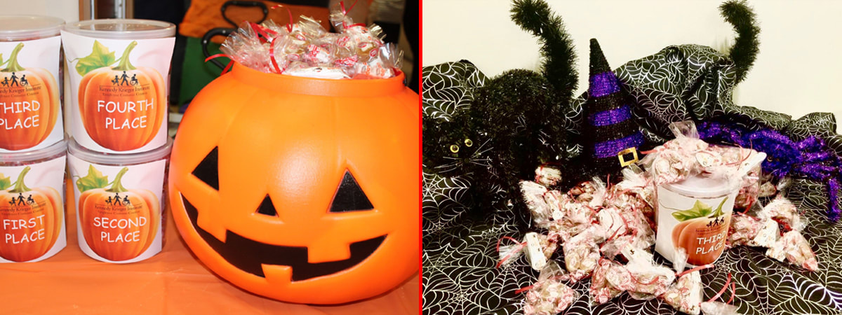 Containers labeled with Halloween-themed prizes and filled with Cow Tales candy, surrounded by decorations like a jack-o’-lantern bucket, sparkly black cats, and witch hats.