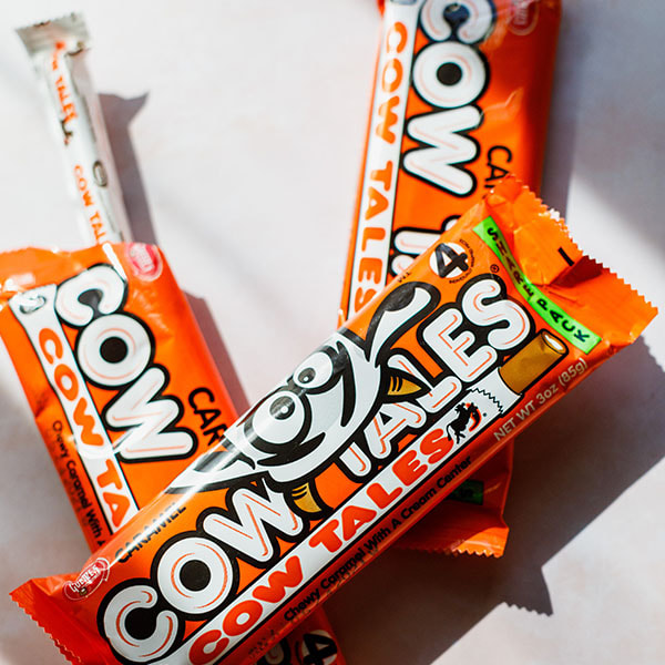 Three packs of Caramel Cow Tales 4-packs with one sticking out.