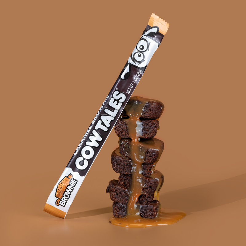 Caramel Brownie Cow Tale® sitting on a stack of caramel covered brownies.