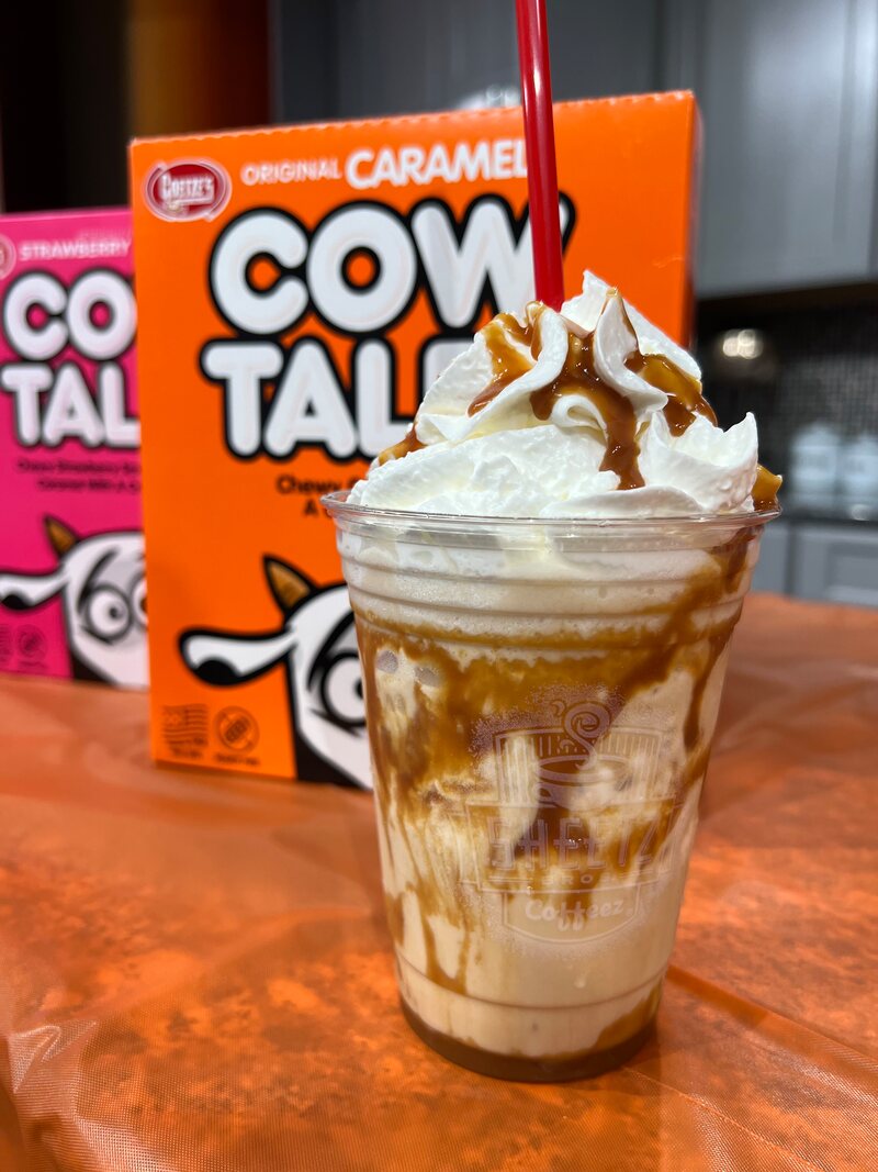 Caramel Cow Tales milkshake topped with whipped cream and a drizzle of caramel sauce.

