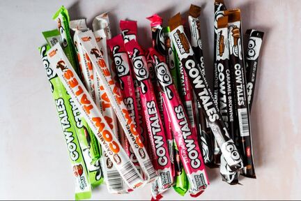 A small handful of Cow Tales candies in assorted flavors: Caramel, Caramel Apple, Caramel Brownie, and Strawberry Smoothie.