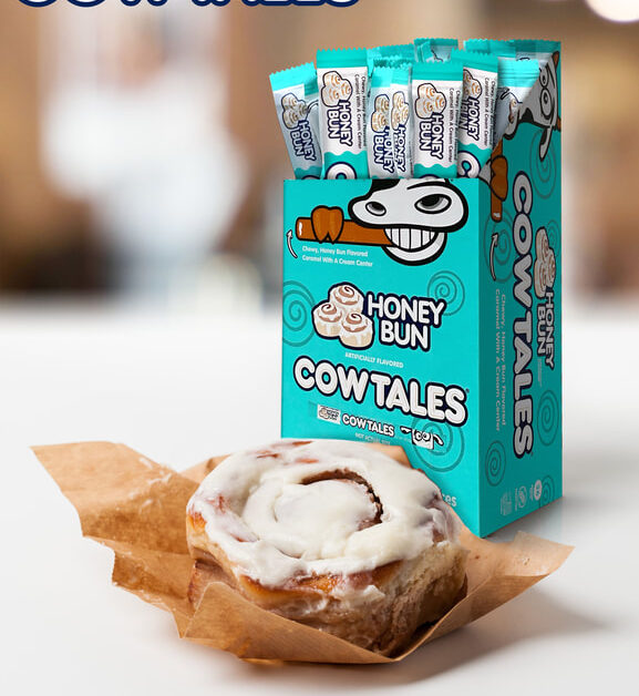 Honey Bun Cow Tales® pack with an actual honey bun sitting in front of it on a brown wrapper.
