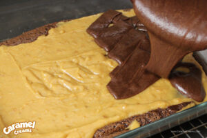Caramel and chocolate poured on top of baked brownie