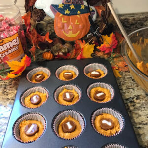 Pumpkin caramel muffins in the muffin baking tray prepped for the oven with caramel creams on top