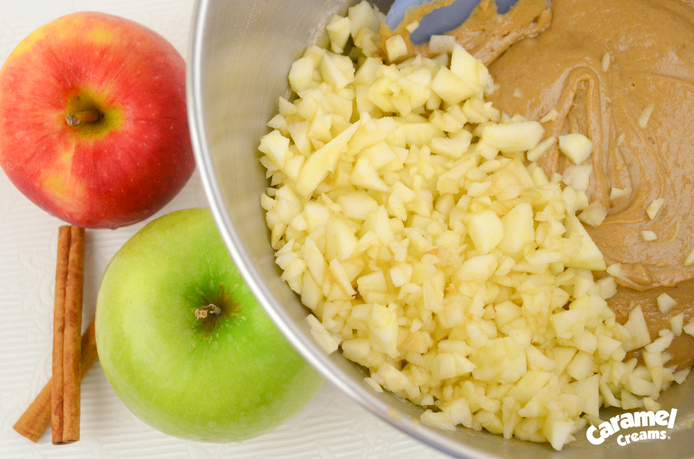 Diced apple in a mixing bowl with caramel mixture